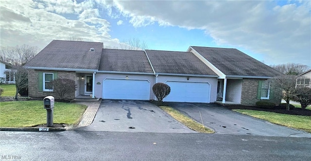 view of front of home featuring a front lawn, brick siding, a garage, and driveway