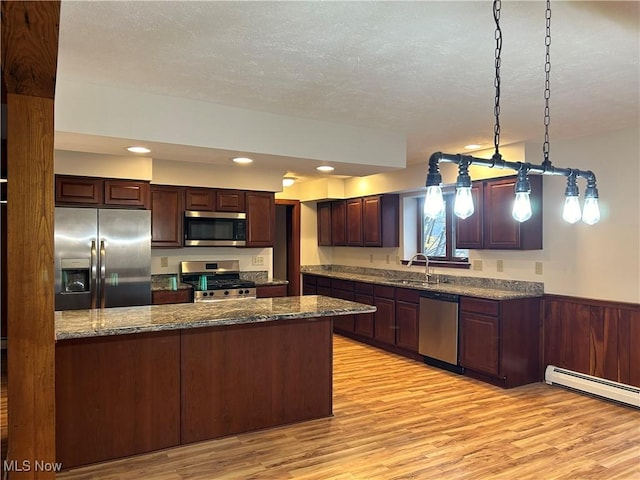 kitchen featuring a sink, dark brown cabinetry, appliances with stainless steel finishes, a baseboard heating unit, and light wood-type flooring