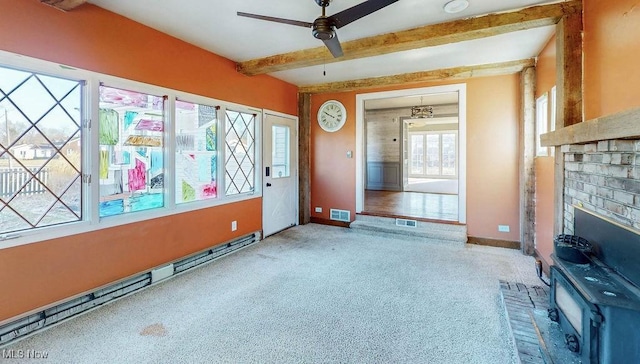 unfurnished living room featuring beamed ceiling, carpet, visible vents, and ceiling fan