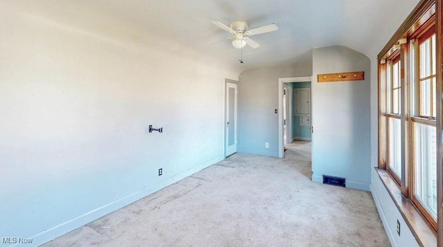 empty room with light carpet, baseboards, visible vents, and ceiling fan