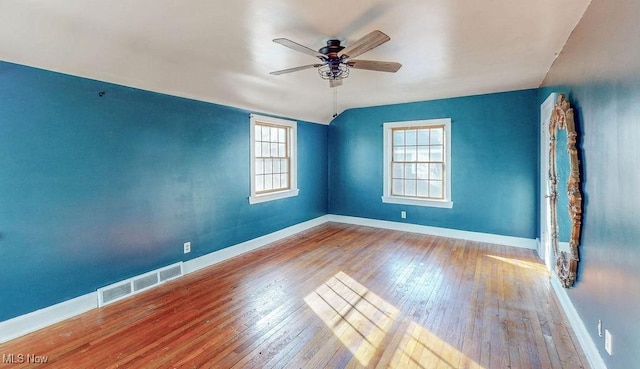 unfurnished room with hardwood / wood-style flooring, baseboards, and visible vents