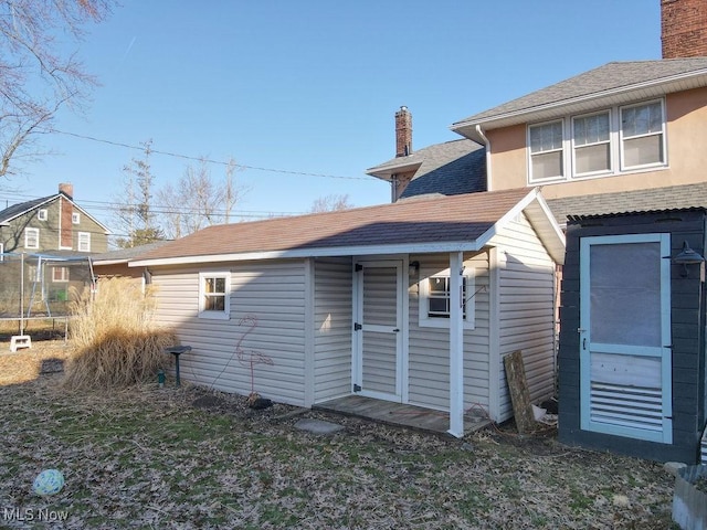 exterior space featuring a shingled roof and a chimney