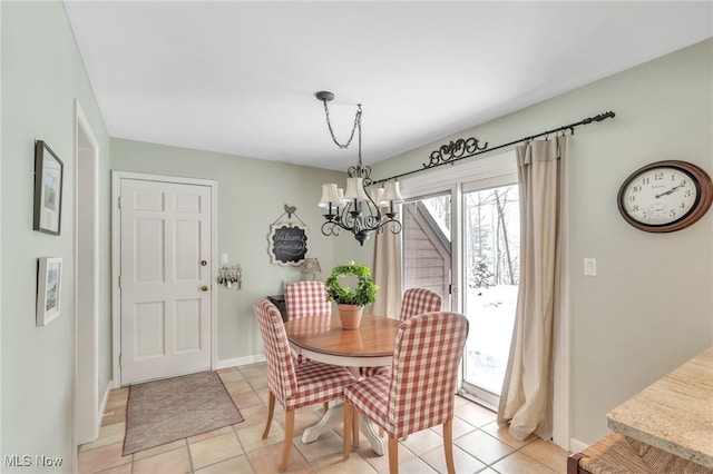 dining area with light tile patterned floors, baseboards, and a chandelier