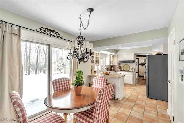 dining space featuring a notable chandelier and light tile patterned flooring