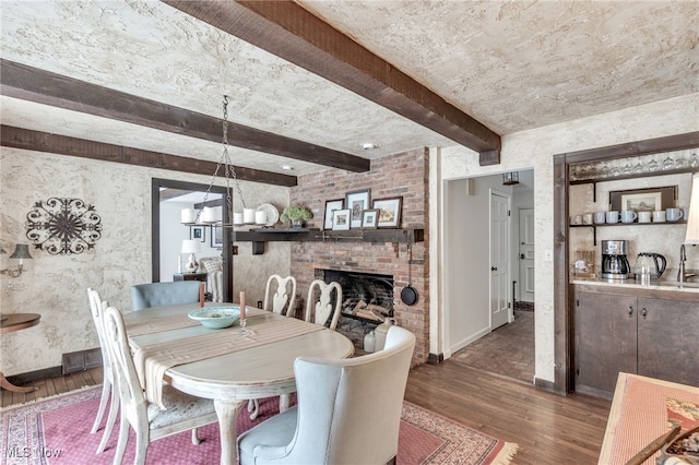 dining space featuring beamed ceiling, baseboards, visible vents, and wood finished floors