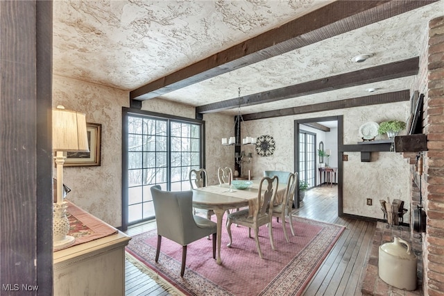 dining space featuring beamed ceiling and hardwood / wood-style flooring