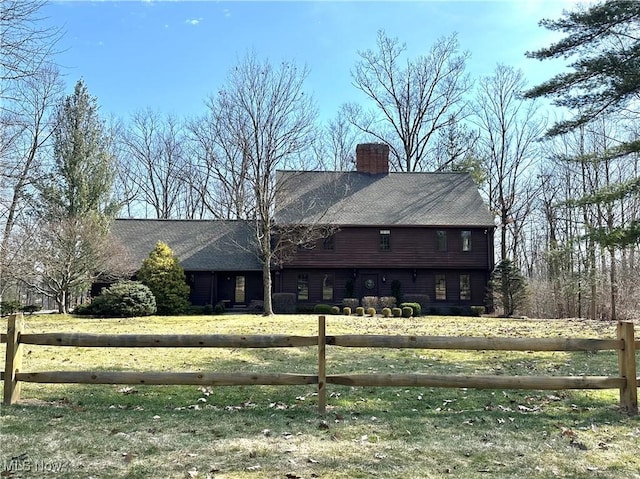 back of house featuring fence and a chimney