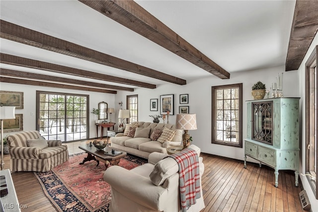 living area with beam ceiling, baseboards, and hardwood / wood-style floors