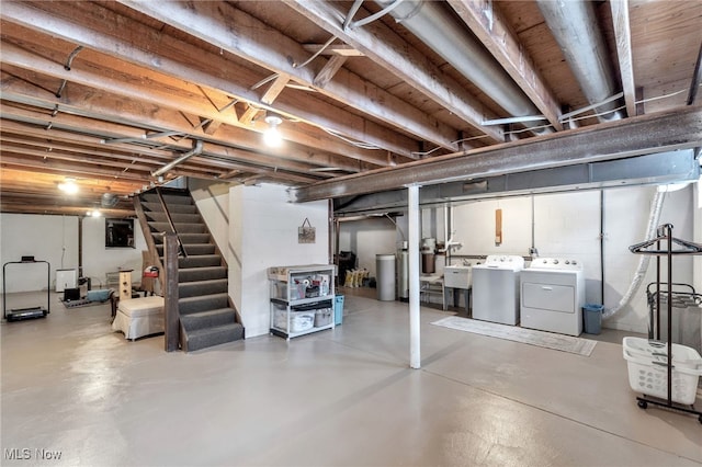 unfinished below grade area featuring stairs, a sink, and washer and clothes dryer