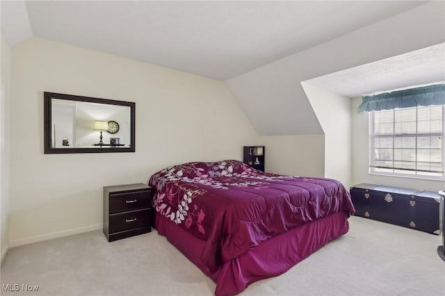 carpeted bedroom with baseboards and lofted ceiling