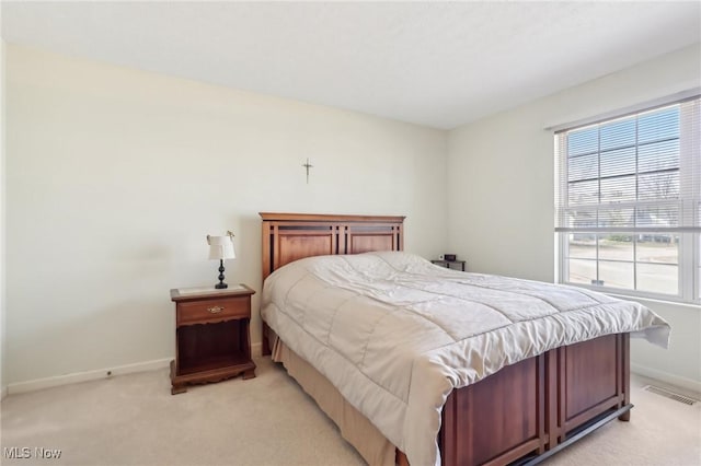 bedroom featuring baseboards, visible vents, and light carpet