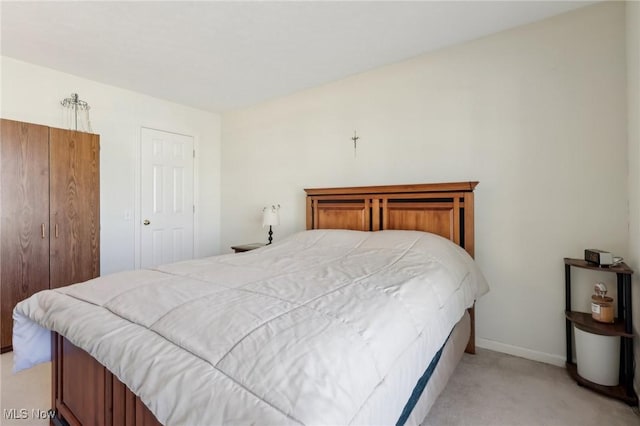 bedroom featuring light colored carpet and baseboards