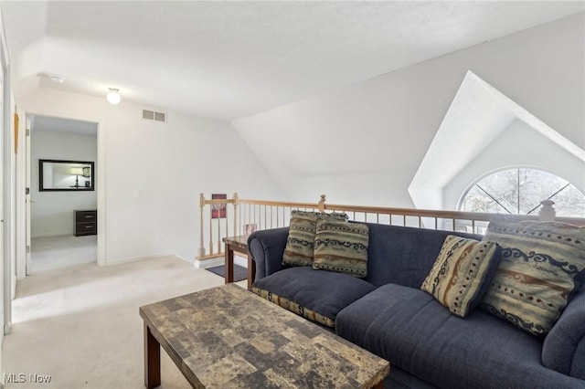 living area with lofted ceiling, baseboards, visible vents, and carpet floors