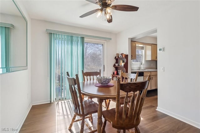 dining area featuring ceiling fan, baseboards, and wood finished floors