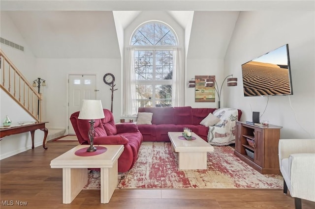 living room featuring visible vents, stairs, lofted ceiling, and wood finished floors