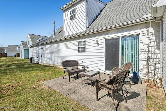 rear view of house featuring central air condition unit, a lawn, a shingled roof, and a patio area