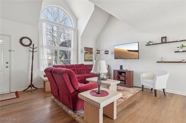 living room with vaulted ceiling, wood finished floors, and baseboards