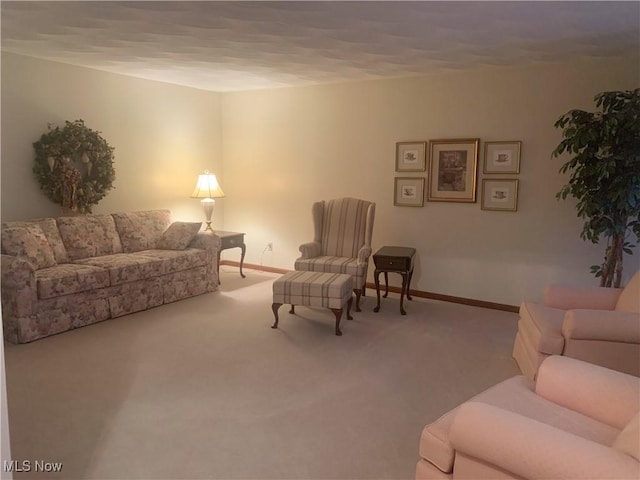 living area featuring carpet flooring and baseboards