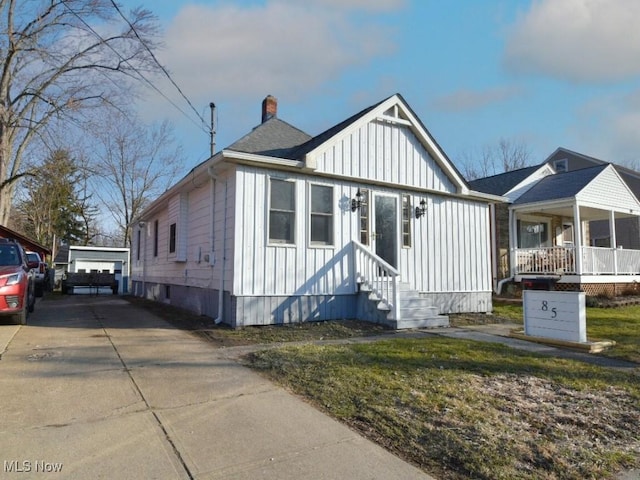 view of front of home featuring board and batten siding, a chimney, and entry steps