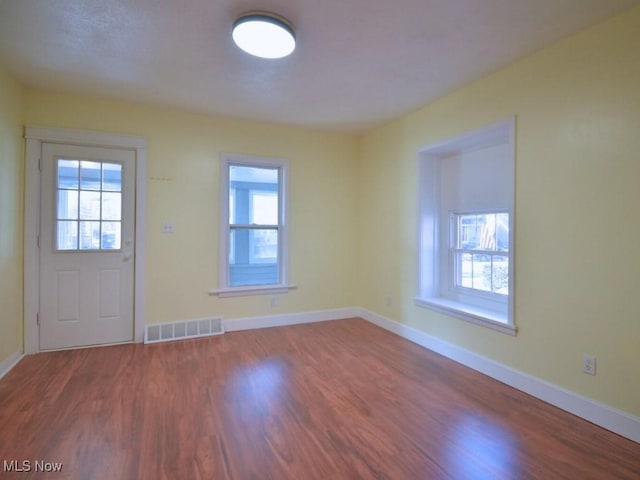 entrance foyer featuring visible vents, baseboards, and wood finished floors