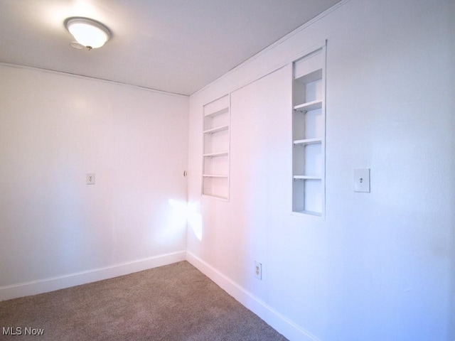 carpeted spare room featuring baseboards