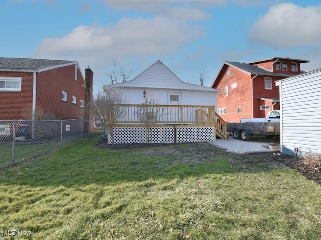 back of house with a wooden deck, a yard, and fence