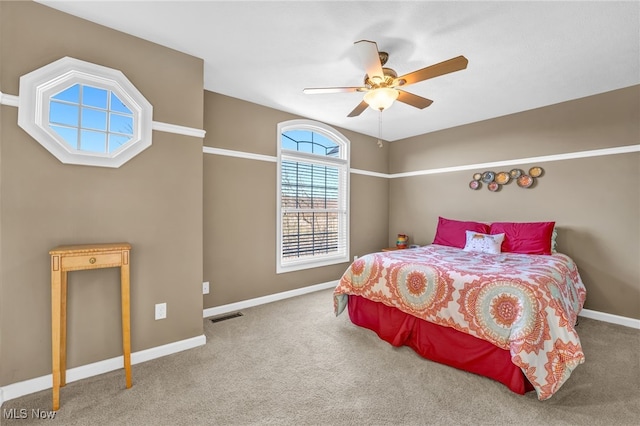 carpeted bedroom featuring visible vents, baseboards, and a ceiling fan