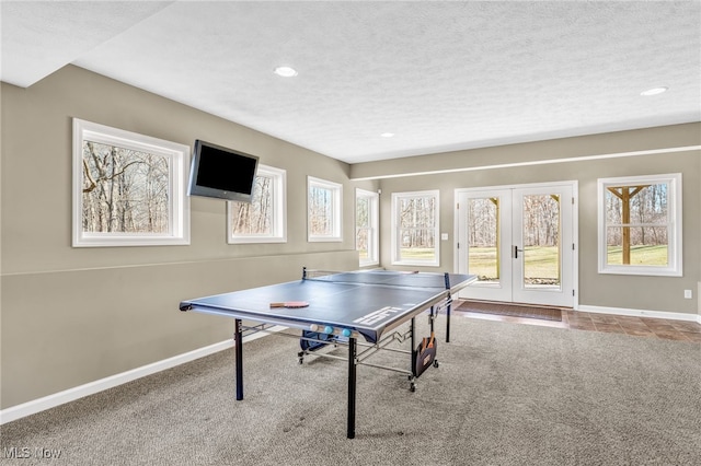 rec room with a wealth of natural light, carpet flooring, and a textured ceiling