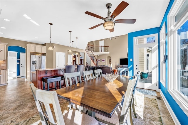 dining room with recessed lighting, arched walkways, baseboards, ceiling fan, and stairs