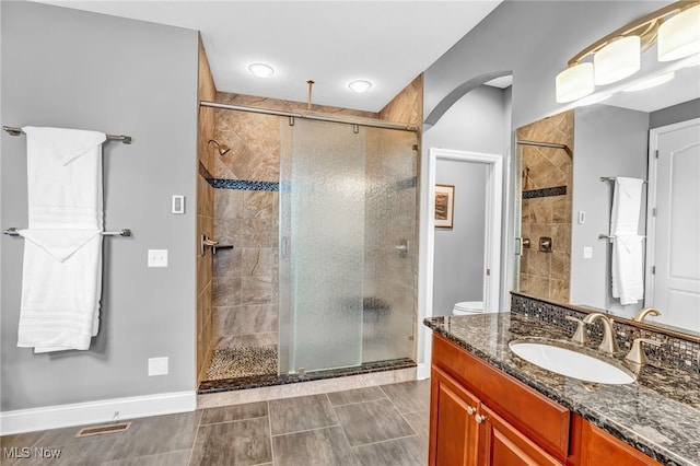 full bath featuring visible vents, a stall shower, vanity, and baseboards