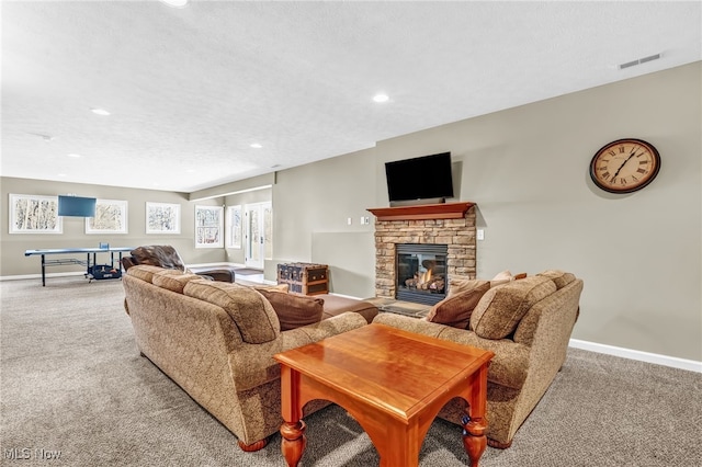 carpeted living room featuring visible vents, a fireplace, a textured ceiling, and baseboards