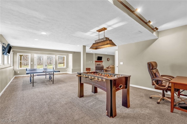 recreation room with baseboards and carpet flooring