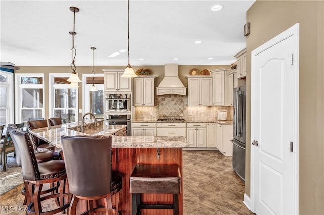 kitchen with a breakfast bar area, a spacious island, stainless steel appliances, custom range hood, and tasteful backsplash