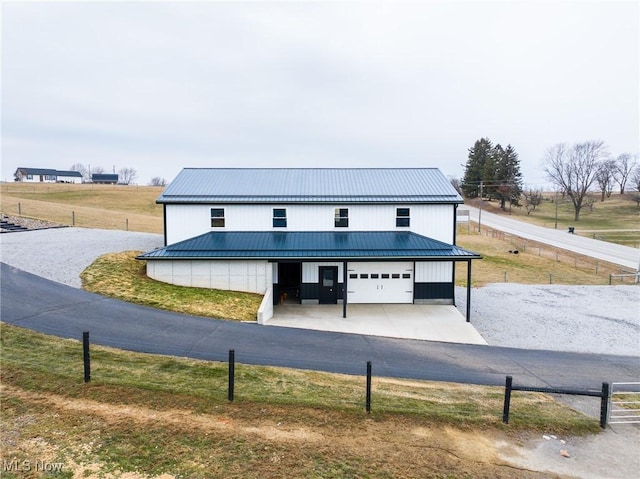 modern farmhouse style home featuring a garage, metal roof, and fence