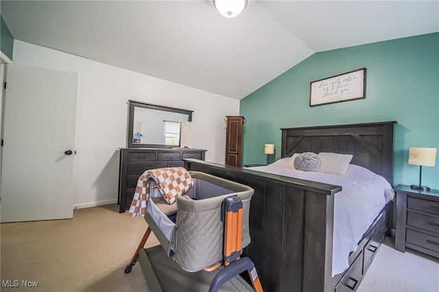 carpeted bedroom featuring baseboards and lofted ceiling