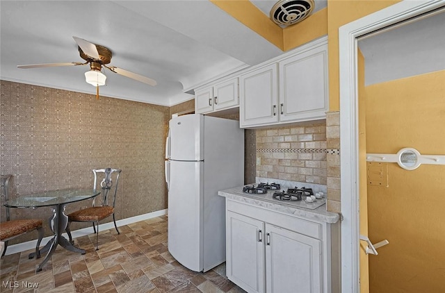 kitchen featuring white appliances, a ceiling fan, decorative backsplash, light countertops, and white cabinetry