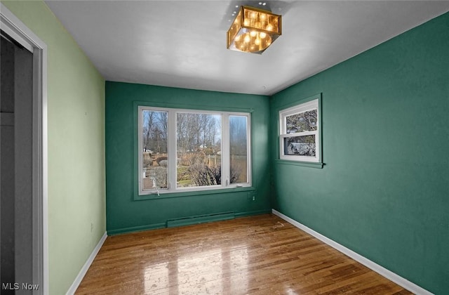 empty room with baseboards and wood finished floors