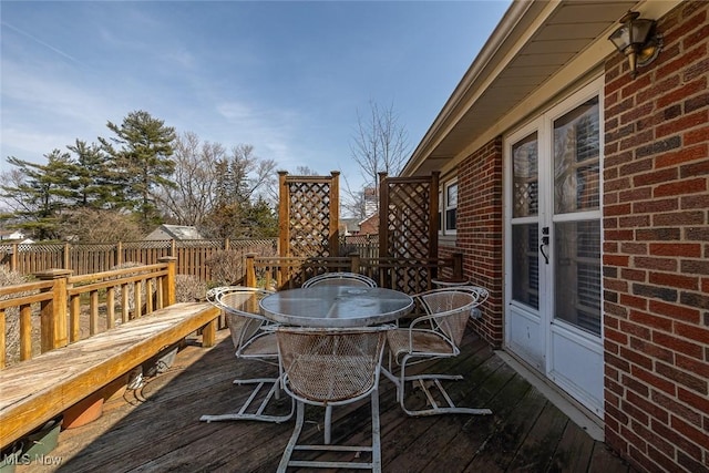 wooden deck with outdoor dining area and fence