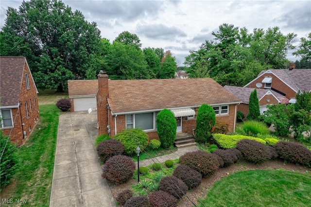 ranch-style home featuring a front lawn, an outdoor structure, a garage, brick siding, and a chimney