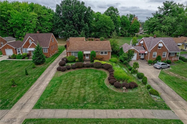 view of front of house with brick siding, a garage, driveway, and a front yard