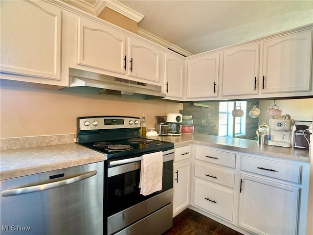 kitchen with dark wood-type flooring, under cabinet range hood, light countertops, white cabinets, and stainless steel appliances