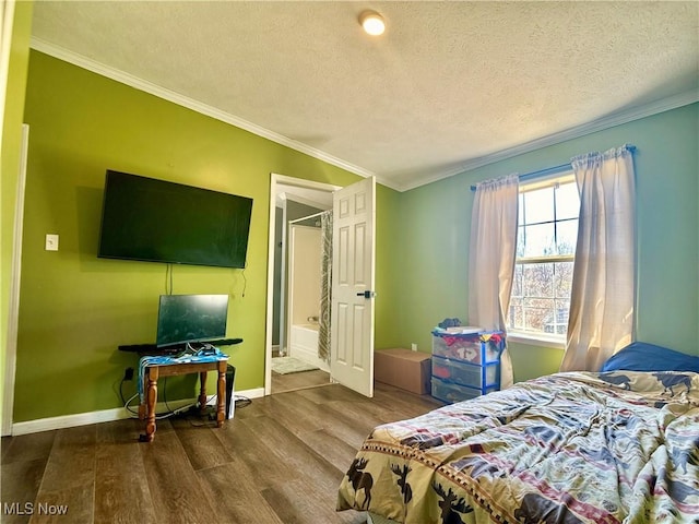 bedroom with ornamental molding, a textured ceiling, baseboards, and wood finished floors