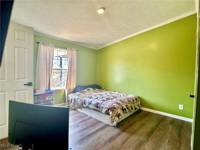 bedroom featuring ornamental molding, baseboards, and wood finished floors