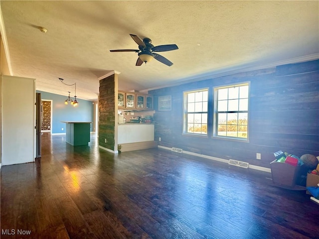 unfurnished living room featuring visible vents, a textured ceiling, dark wood-style floors, and ceiling fan with notable chandelier