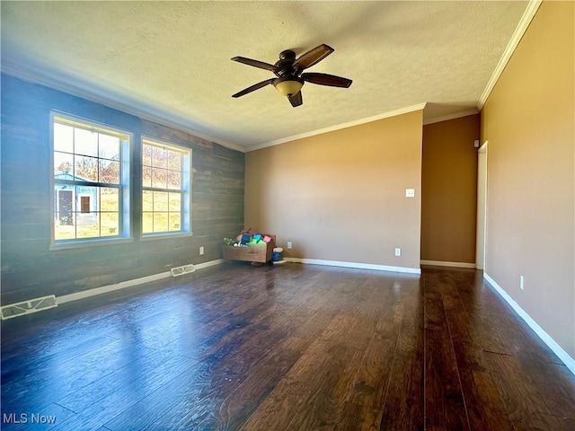 spare room featuring crown molding, baseboards, wood finished floors, a textured ceiling, and a ceiling fan