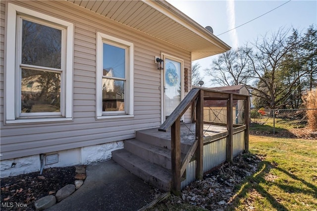 property entrance featuring crawl space and fence