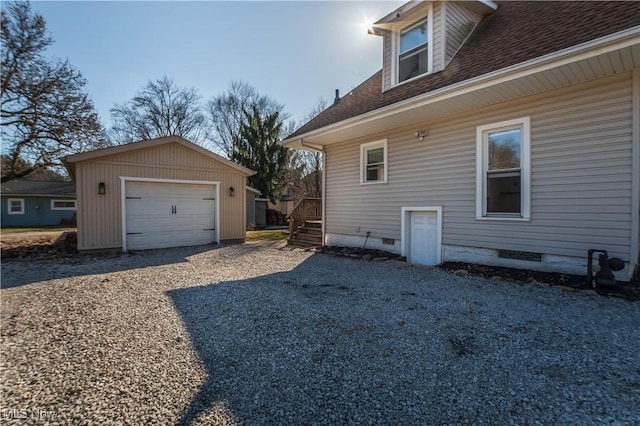 view of home's exterior with roof with shingles, gravel driveway, an outdoor structure, crawl space, and a detached garage