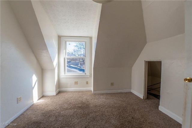 bonus room featuring vaulted ceiling, a textured ceiling, baseboards, and carpet floors