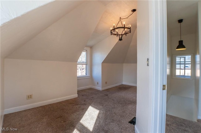 bonus room featuring an inviting chandelier, baseboards, carpet, and vaulted ceiling