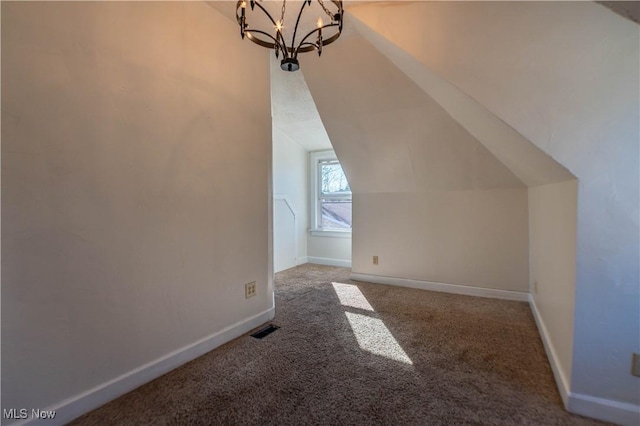 bonus room featuring baseboards, visible vents, carpet floors, vaulted ceiling, and a notable chandelier